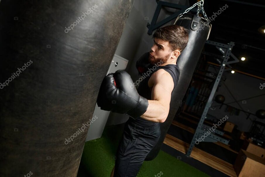 薄暗い地下ジムでバンテージを巻く男の拳